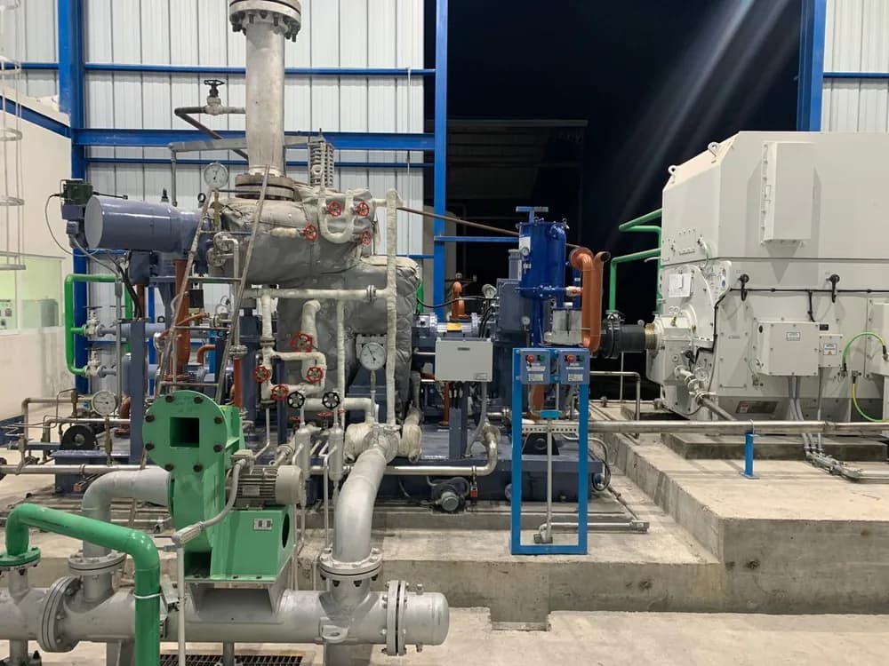 Sala de una planta de cogeneración con la turbina, la tubería y el generador al fondo