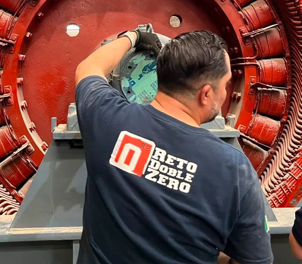 Técnicos de Grupo Möller con playeras del Reto Doble Zero trabajando en el estator de un generador
