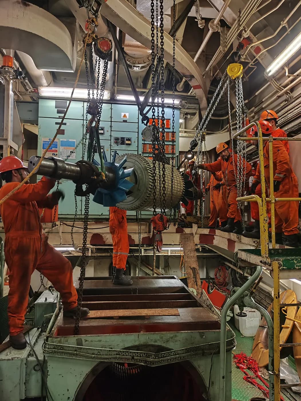 Equipo de Grupo Möller maniobrando un generador con polipastos dentro de la sala de máquinas de un barco