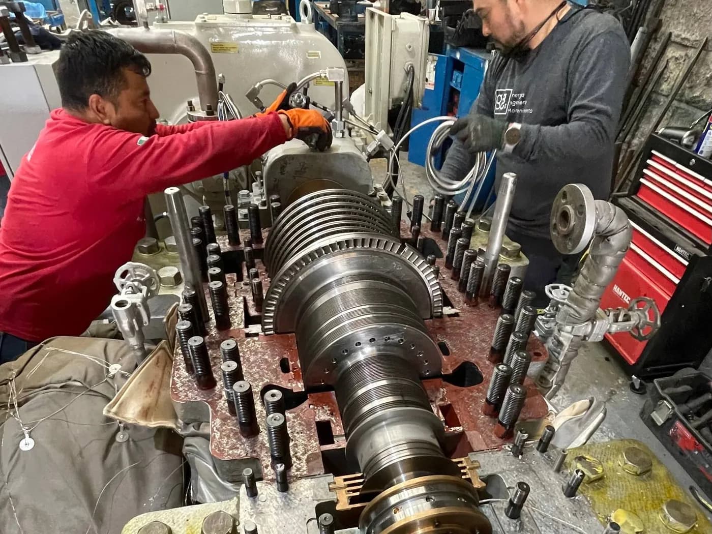 Dos técnicos de Grupo Möller trabajando sobre el rotor abierto de una turbina de vapor en el taller